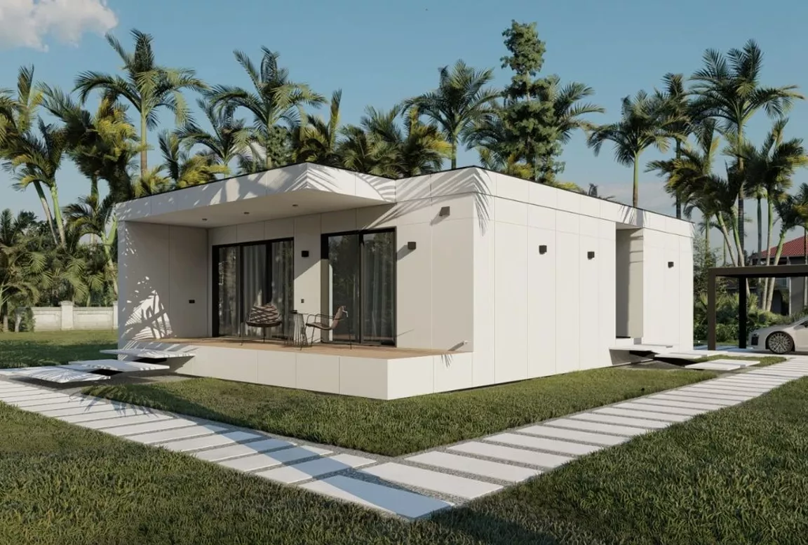 Elegant white modular home with a minimalist design, front porch area, and tropical garden backdrop including palm trees and a parked car in a black-frame carport.